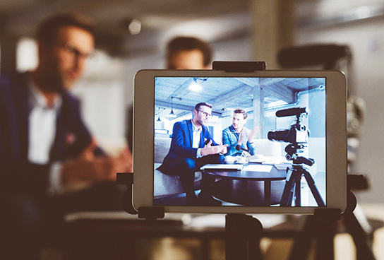 Two employees filming content for social media