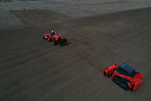 Tractors in a field, filmed by a drone