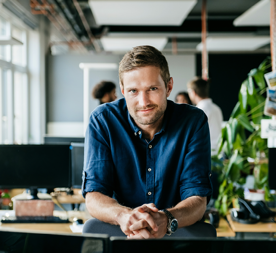 entrepreneur in an office, leaning on his desk