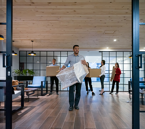 group of people carrying furniture into their new office