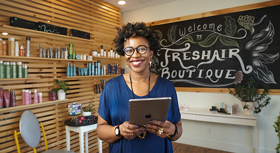 Owner of Freshair Boutique in front of a blackboard