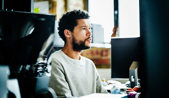 man looking serious working on his computer