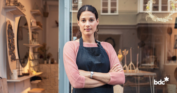 business owner standing in front of her store