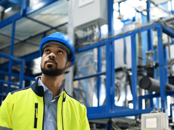 man in yellow vest working in a factory