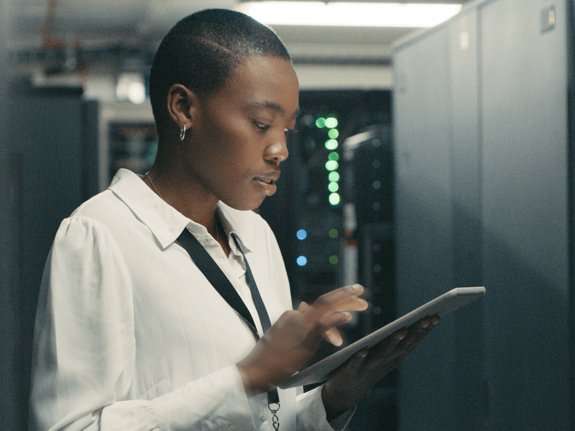 Woman looking at an ipad in a server room