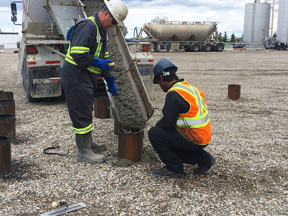 men working with concrete pilings