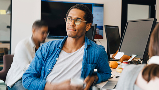 IT worker leaning on his desk with a coffee