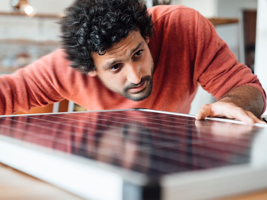 man looking at a small solar panel