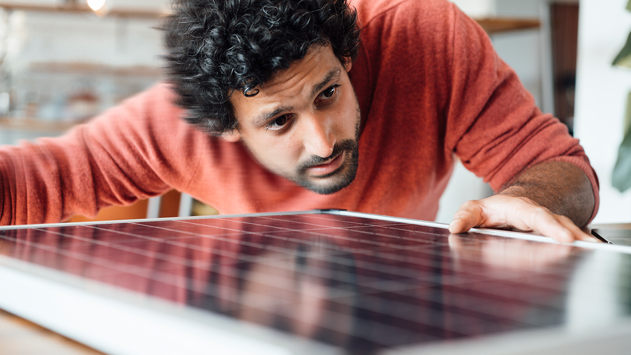 man looking at a small solar panel