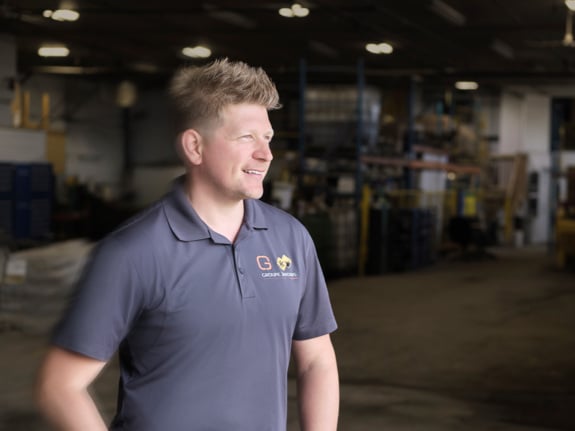 Olivier Girard smiling and standing in warehouse of Groupe Jardins Brossard