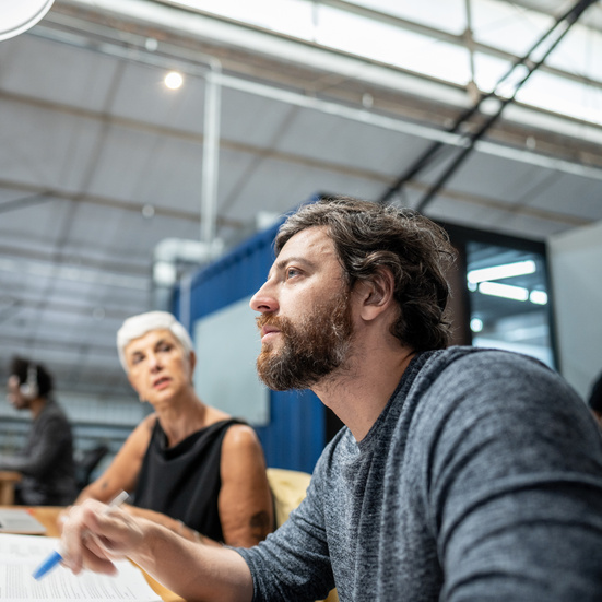 Mid adult businessman talking with coworkers during a meet at office