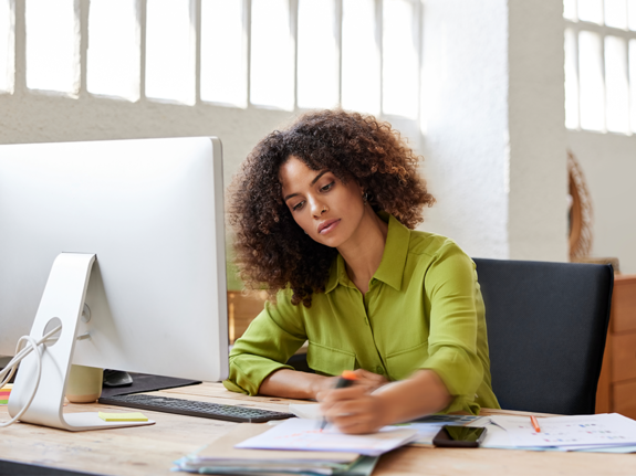 woman with green shirt working, doing paperwork