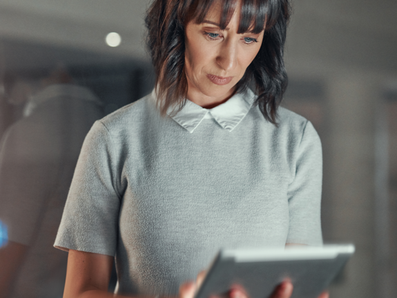 woman looking at an ipad in her office